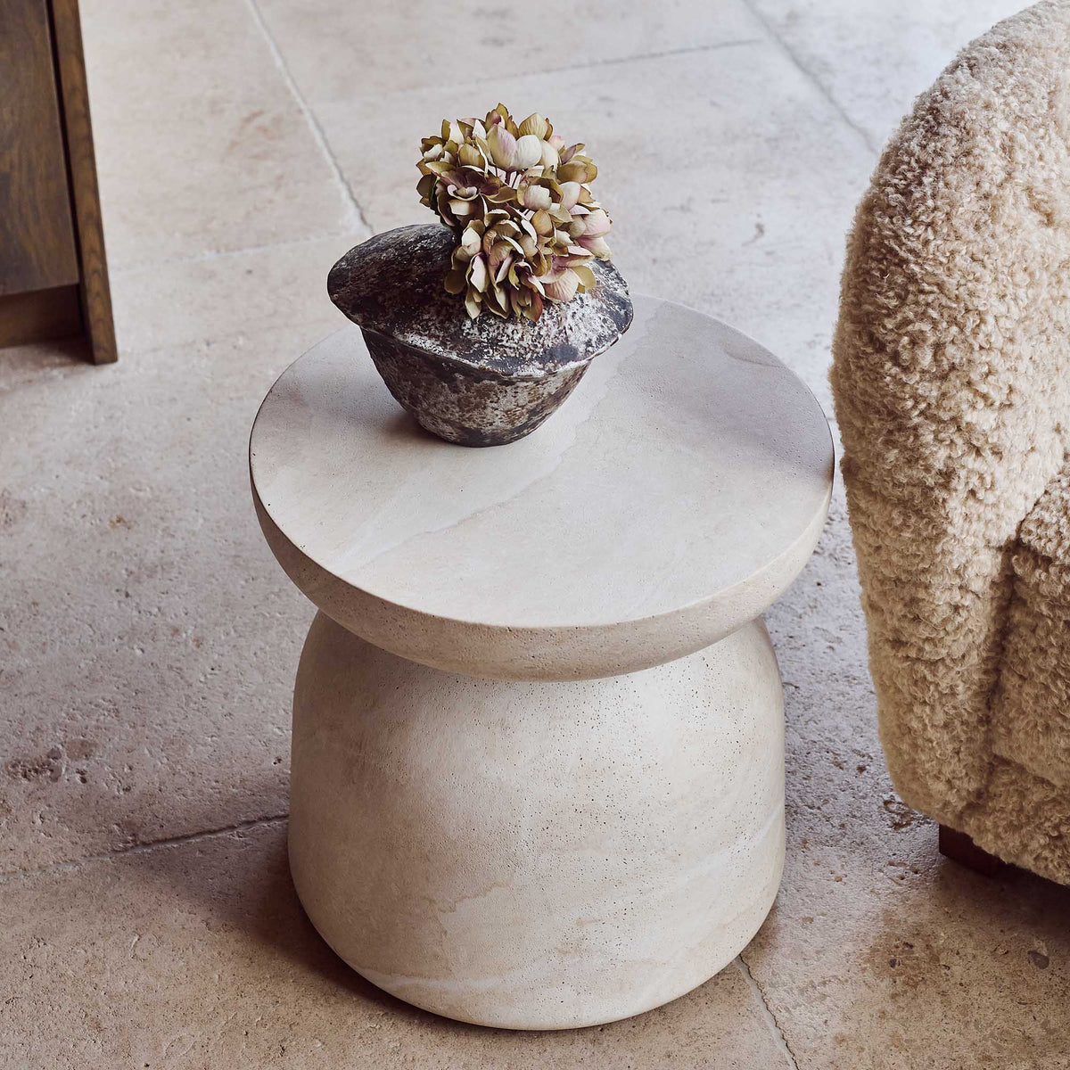 Modern and sculptural, the smooth stone effect Diablo side table in neutral tones, with smooth curved edges & elegant rounded profile perfect as a base to show off a beautiful sculpture or a vase of flowers, perfect for any indoor or outdoor living situation 