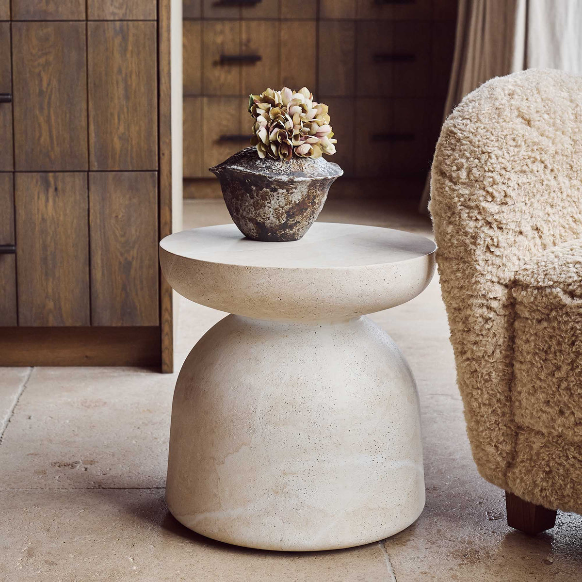 Modern and sculptural, the smooth stone effect Diablo side table in neutral tones, with smooth curved edges & elegant rounded profile perfect as a base to show off a beautiful sculpture or a vase of flowers, perfect for any indoor or outdoor living situation 