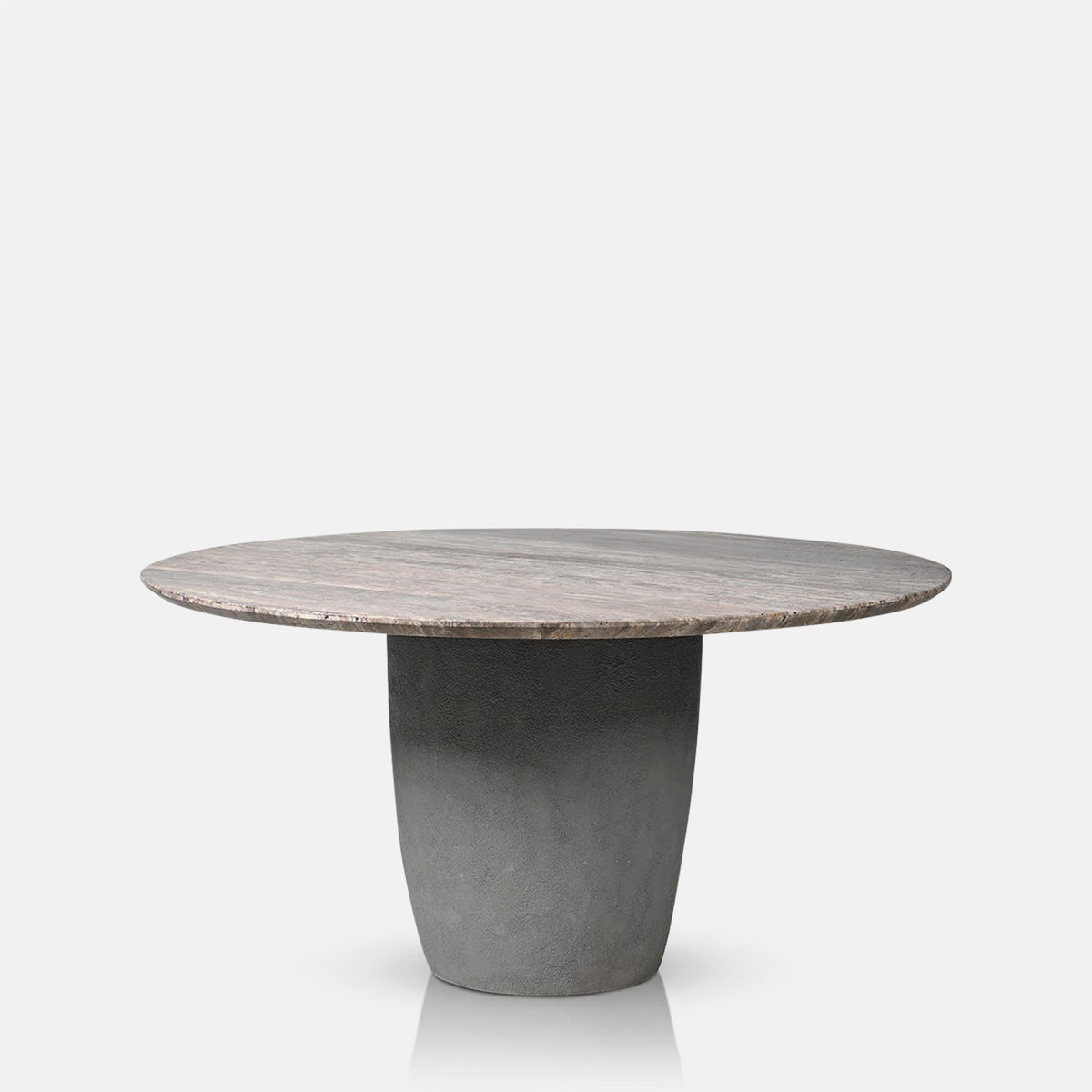 Abigail Ahern Marlen Dining Table with a bold sculptural pedestal base in dark smoky stone, supporting a large round travertine tabletop for contemporary dining spaces.