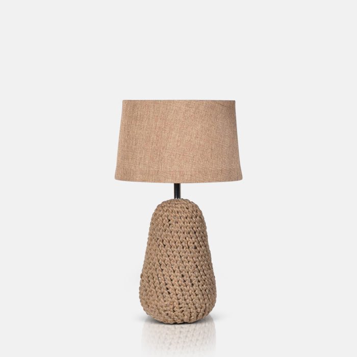 A cutout of the Milton Table Lamp, a table lamp with a chunky knotted base in warm brown and a fabric drum shade.