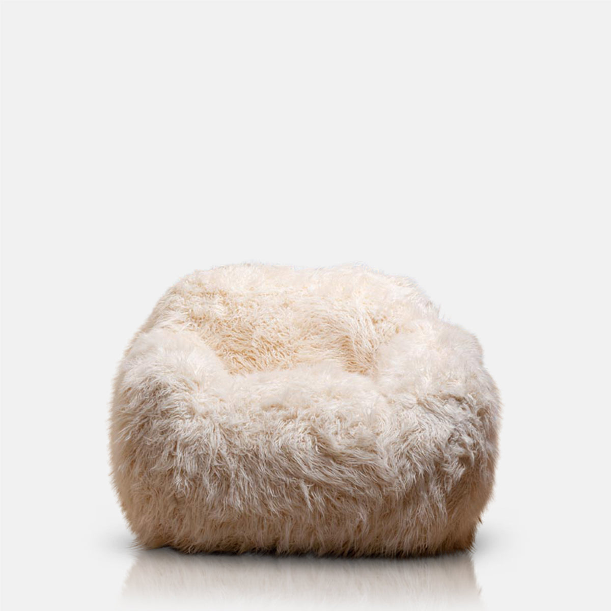 A cutout of Rowley Faux Fur Armchair, a sumptuous oversized armchair upholstered in super soft cream coloured shaggy faux fur.