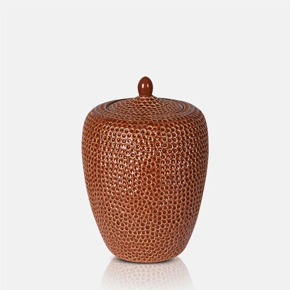 Nara Ceramic Jar in terracotta has a rounded tapering body and fitted lid with a small knob, covered in a glossy repeating dimpled pattern.