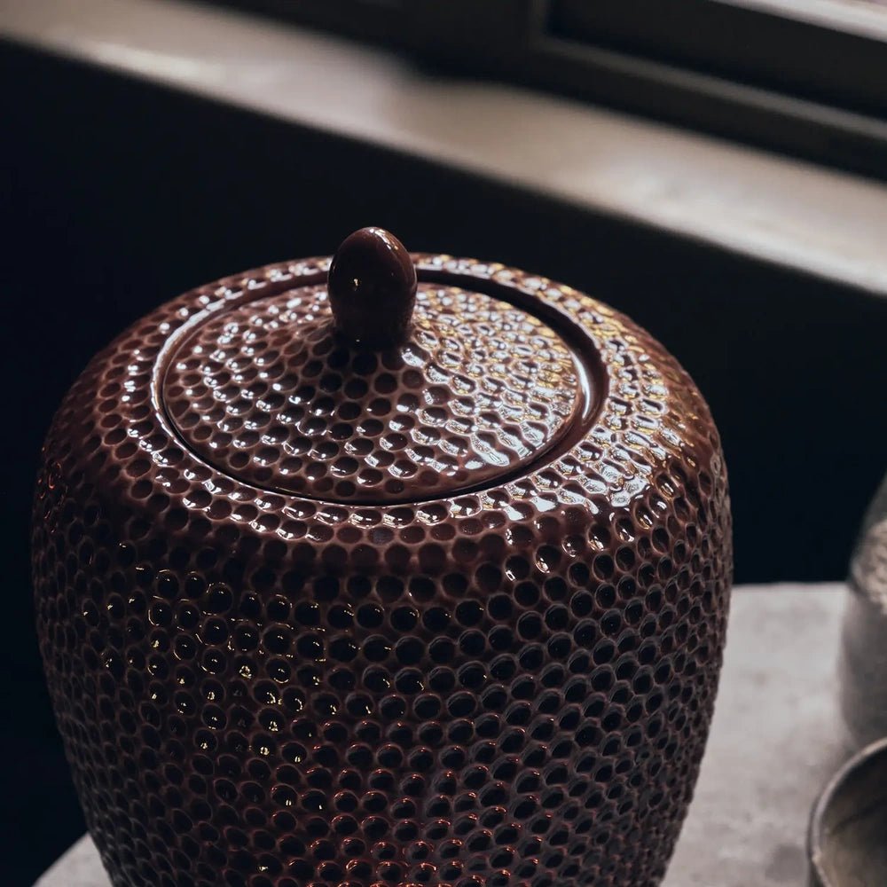 Nara Ceramic Jar features a rounded fitted lid with a small raised knob, shown closely to reveal its glossy terracotta glaze and dimpled surface.