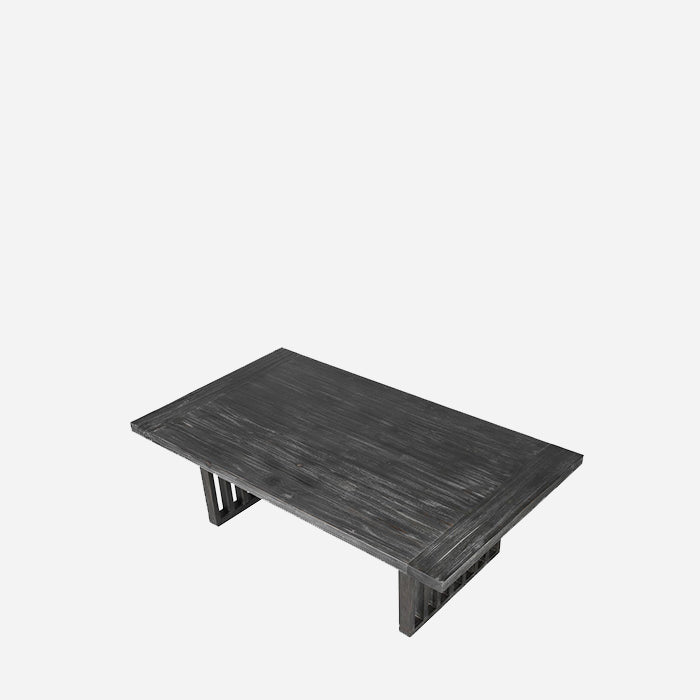 The Newton Grey Wood Coffee Table, a low rectangular table in dark fir wood with a limewash effect and fence-like legs.