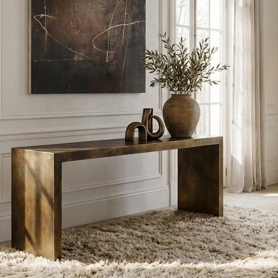 Abigail Ahern Burnished Gold Iron Console Table with a sleek rectangular silhouette and warm metallic finish, creating an elegant but modern statement piece for contemporary living rooms or hallways.