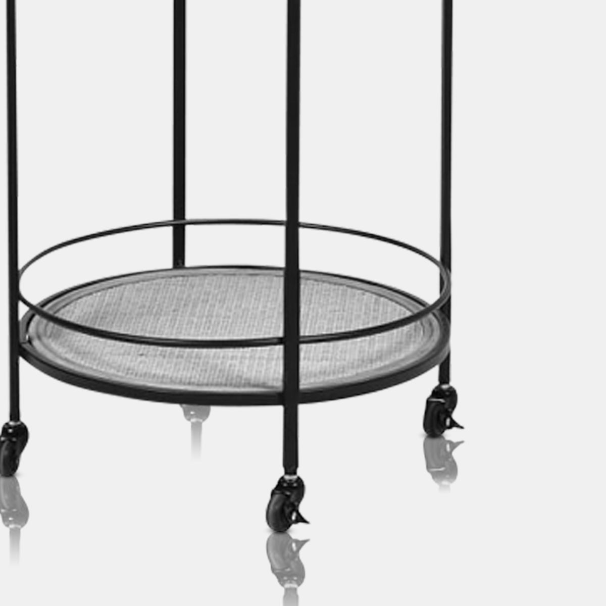 A closeup of the bottom shelf and wheels of the Orwood Round Drinks Trolley.