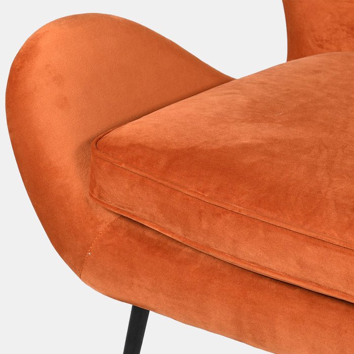 Up close image of the luxury velvet fabric of the Ostra Occasional Chair in a bright orange colour, from bestselling interior design brand Abigail Ahern.