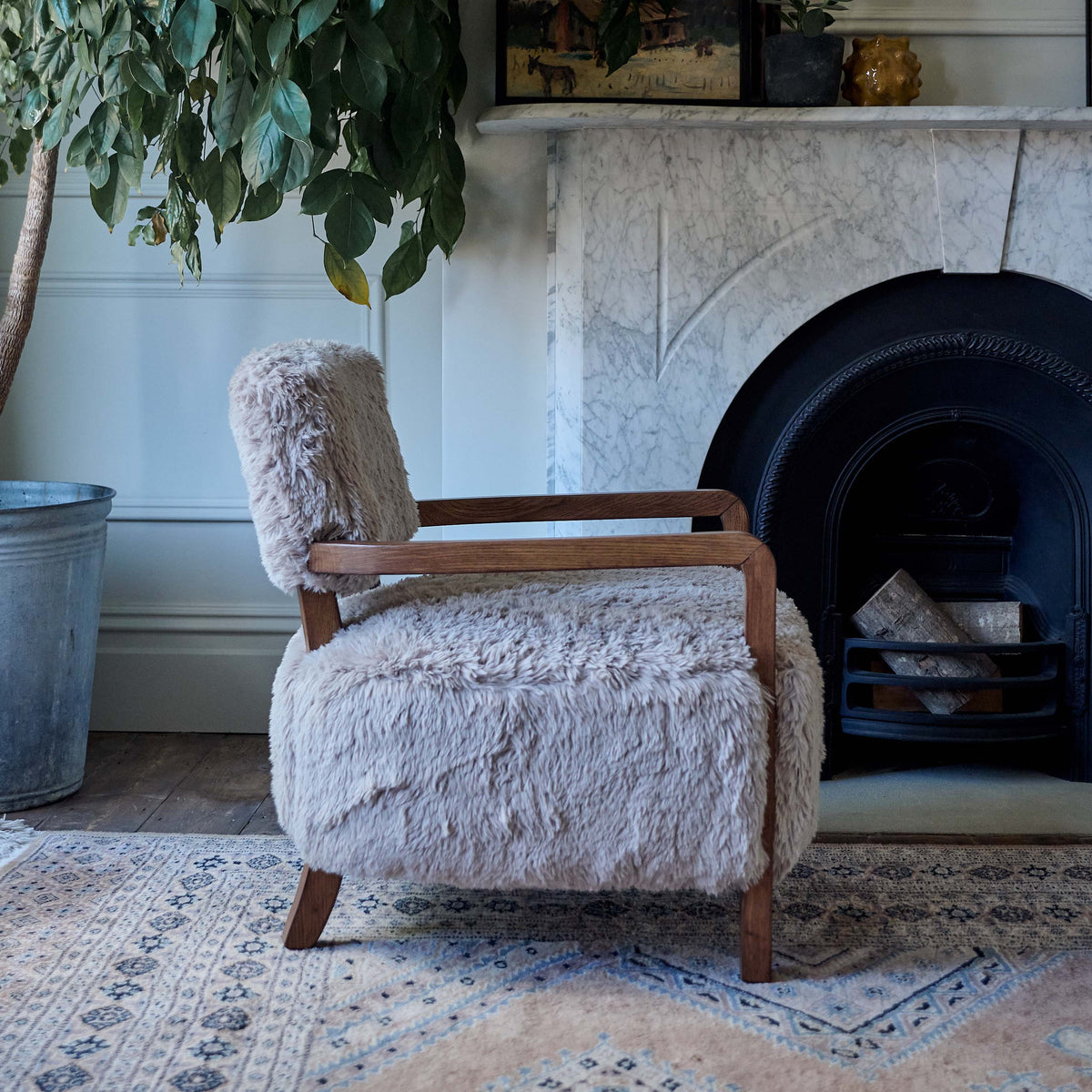 Luxury faux fur armchair featuring a soft textured upholstery, rounded sculptural silhouette, and contemporary organic design with exposed wooden arms complimenting warm neutral tones for modern living spaces.