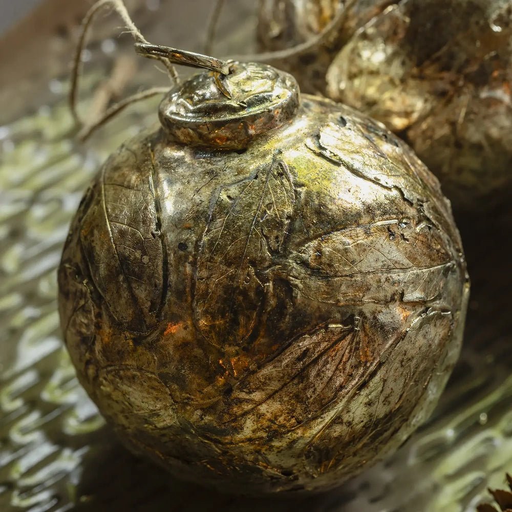 Perth antique silver leaf bauble shows a rounded shape with an aged metallic surface, raised leaf details and a hanging loop in this close view.