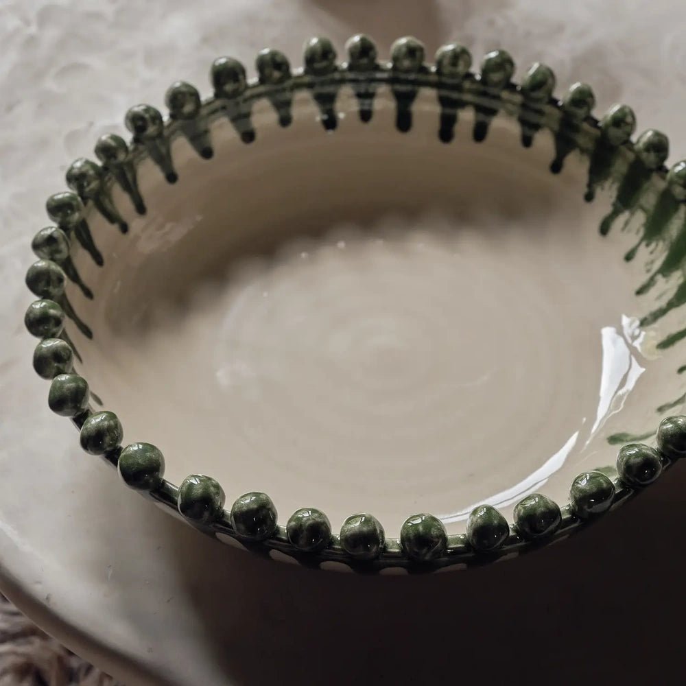 Radcliff bobble decorative bowl with a cream interior and dark green rounded rim details, shown close up to reveal its glossy finish and striped edge.