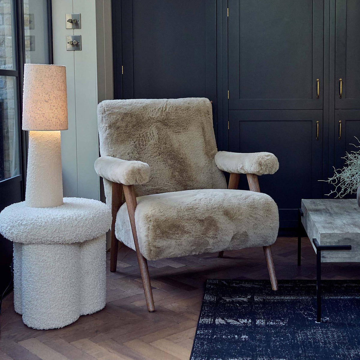 Beige faux sheepskin armchair with a soft textured upholstery, padded armrests and a timeless solid oak frame. Robbins Faux Sheepskin Armchair by Abigail Ahern, a luxury accent chair designed to bring warmth, comfort and natural elegance to modern living rooms, bedrooms and cosy reading corners. A statement piece of furniture perfect for creating a sophisticated, inviting and contemporary interior.