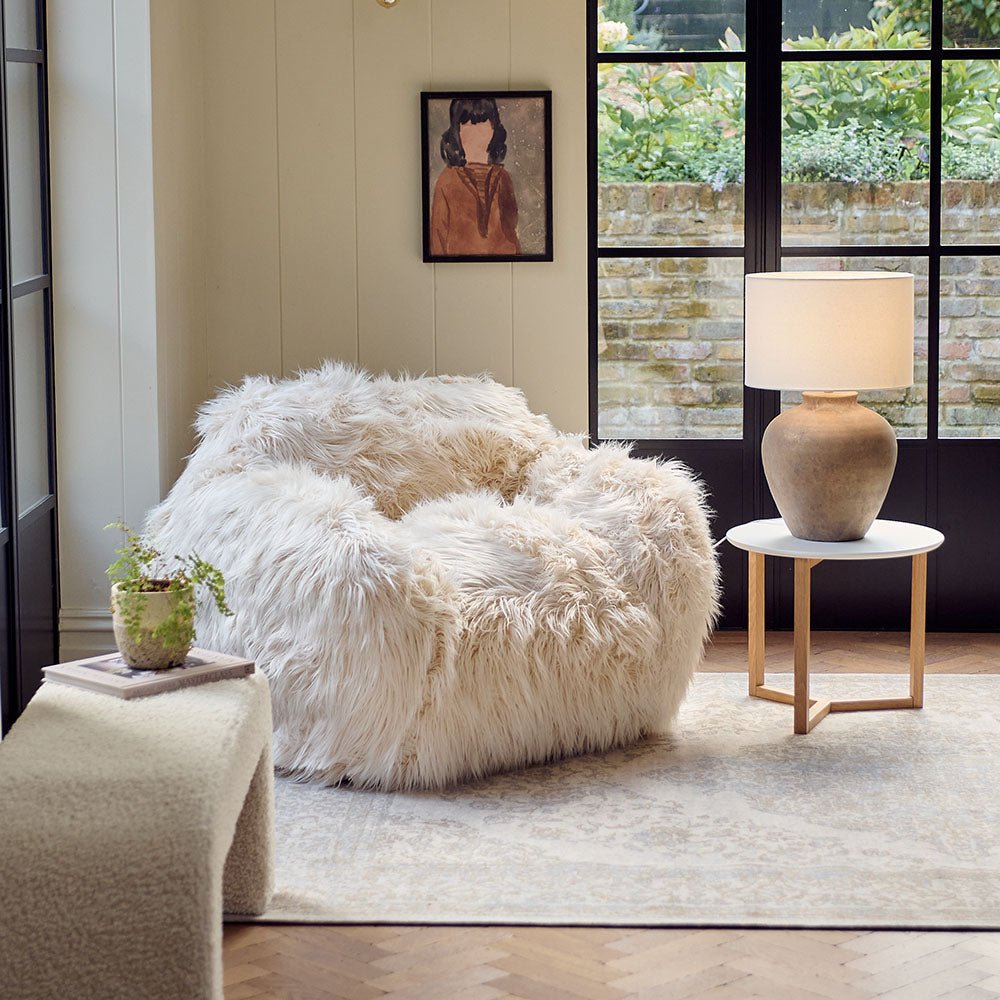 The Rowley Faux Fur Armchair, a sumptuous oversized armchair upholstered in super soft cream coloured shaggy faux fur.