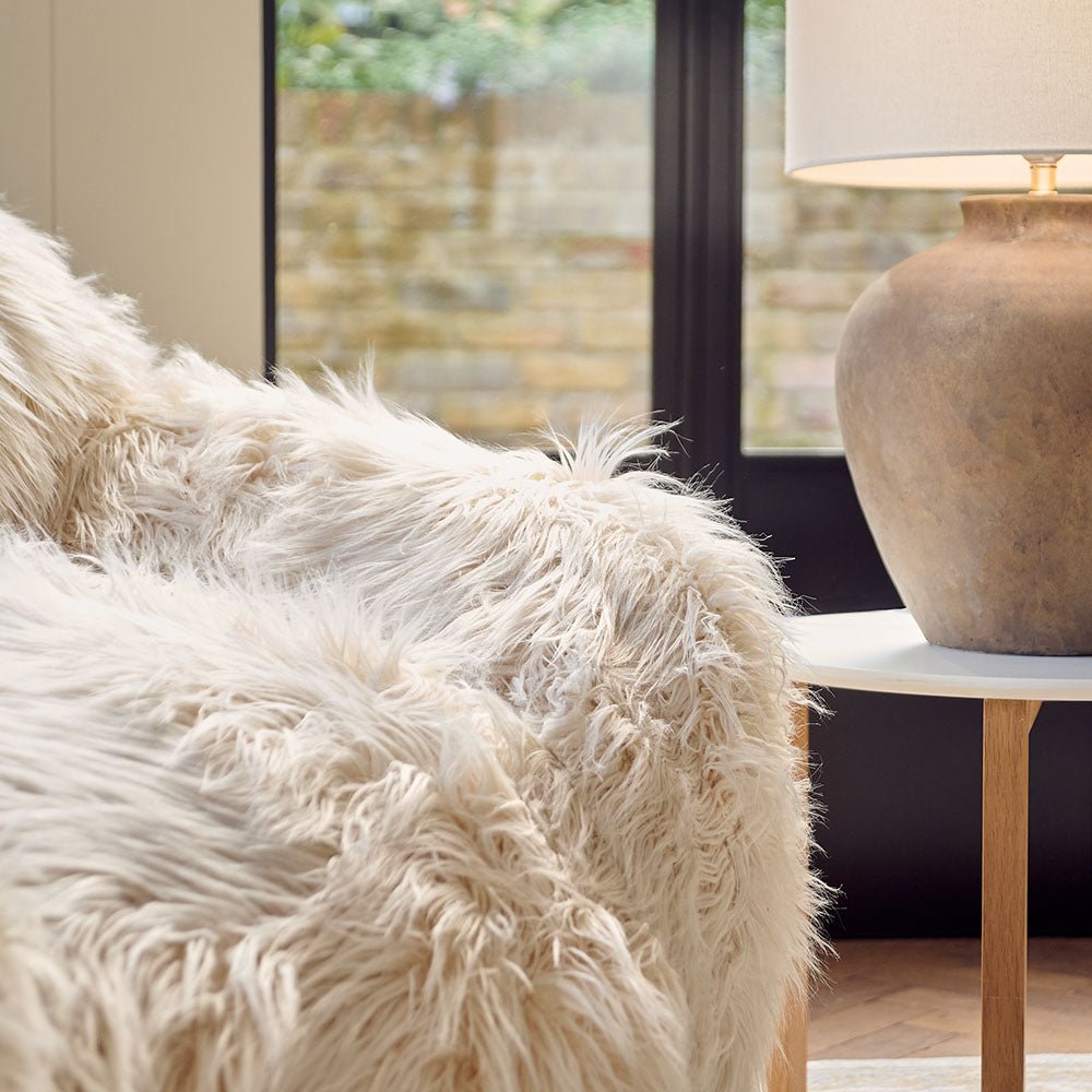The Rowley Faux Fur Armchair, a sumptuous oversized armchair upholstered in super soft cream coloured shaggy faux fur.