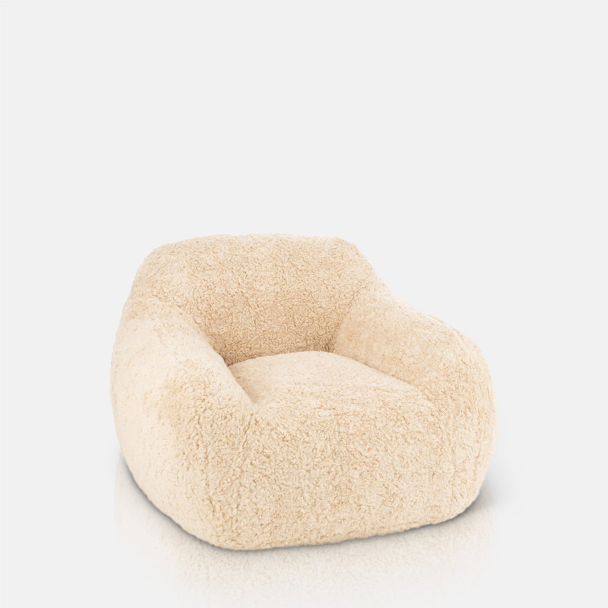 A cutout of the Monroe Faux Shearling Armchair, an oversized cosy tub style chair in cream.