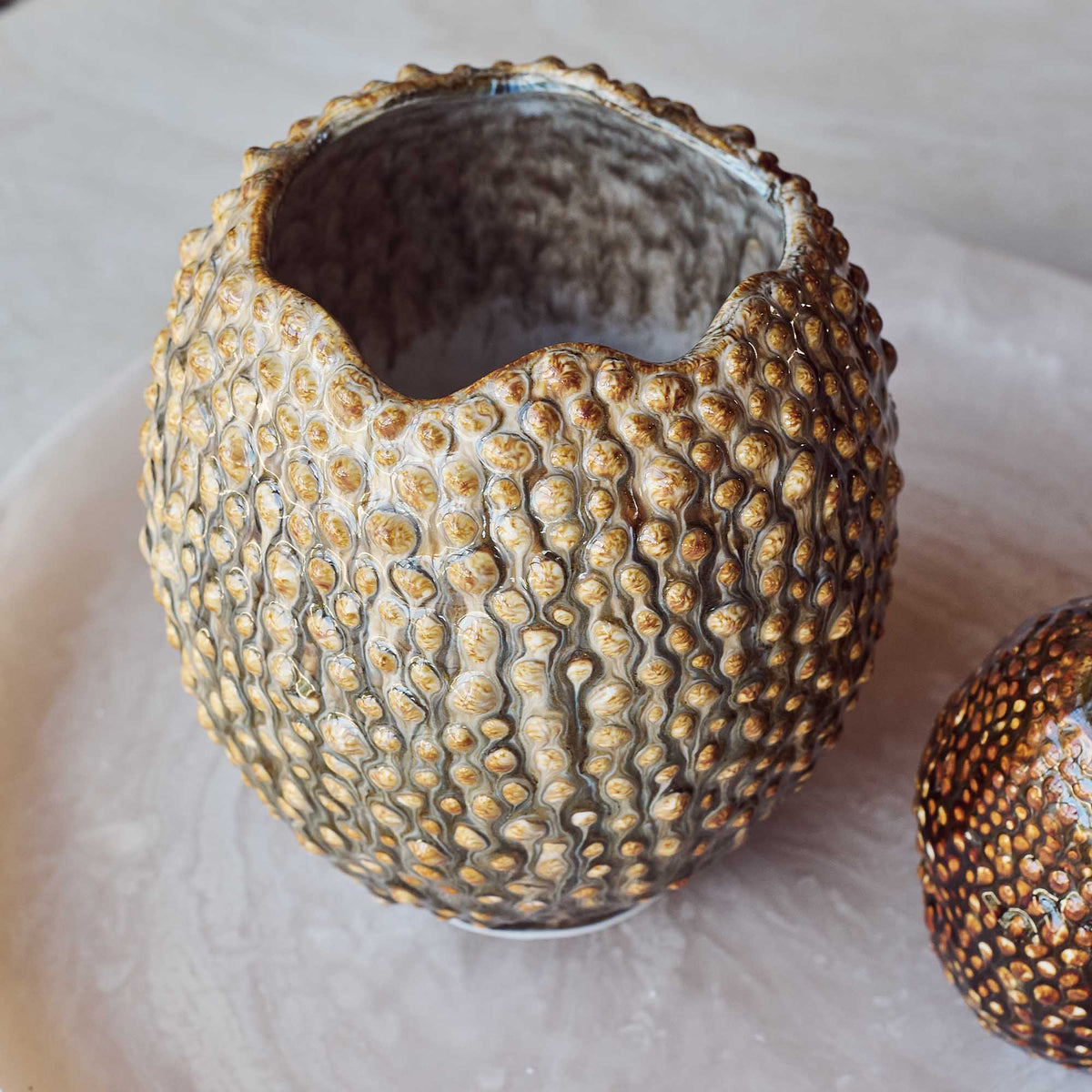 Textured ceramic vase on a light background
