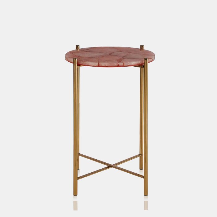Cutout of the Sandon Quartz Side Table, a small round table with a top made of natural pink-hued quartz, with slim gold legs
