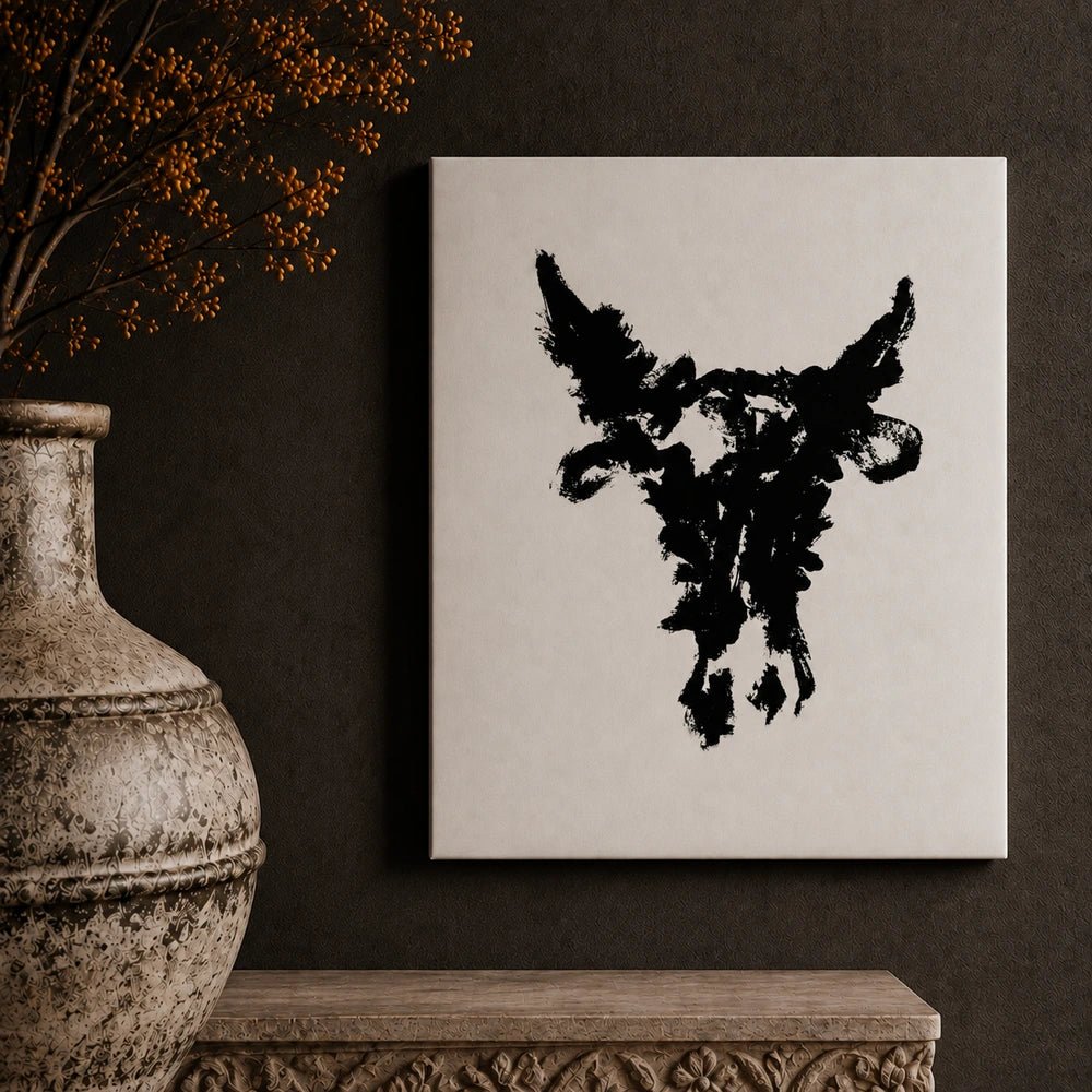 Taurus monochrome bull artwork in a dark frame, displayed above a console with sculptural ceramics, flowers and warm table lamps in a neutral interior.