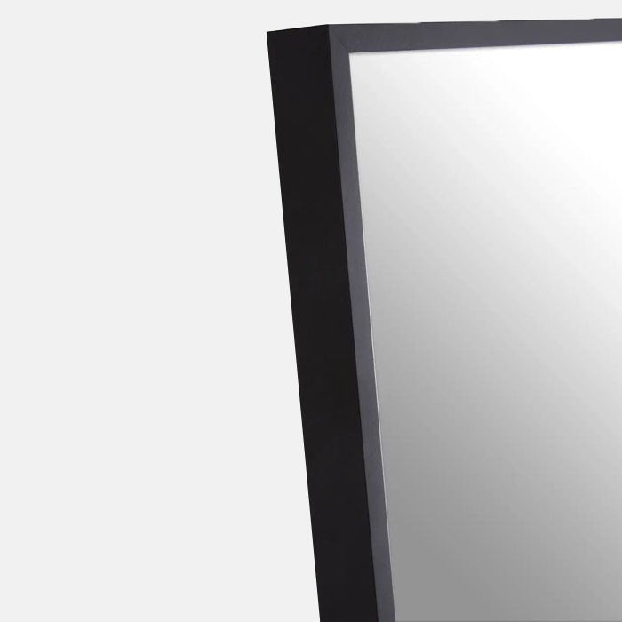 A closeup of the slim gold aluminium frame on the Teresa Black Floor Mirror.