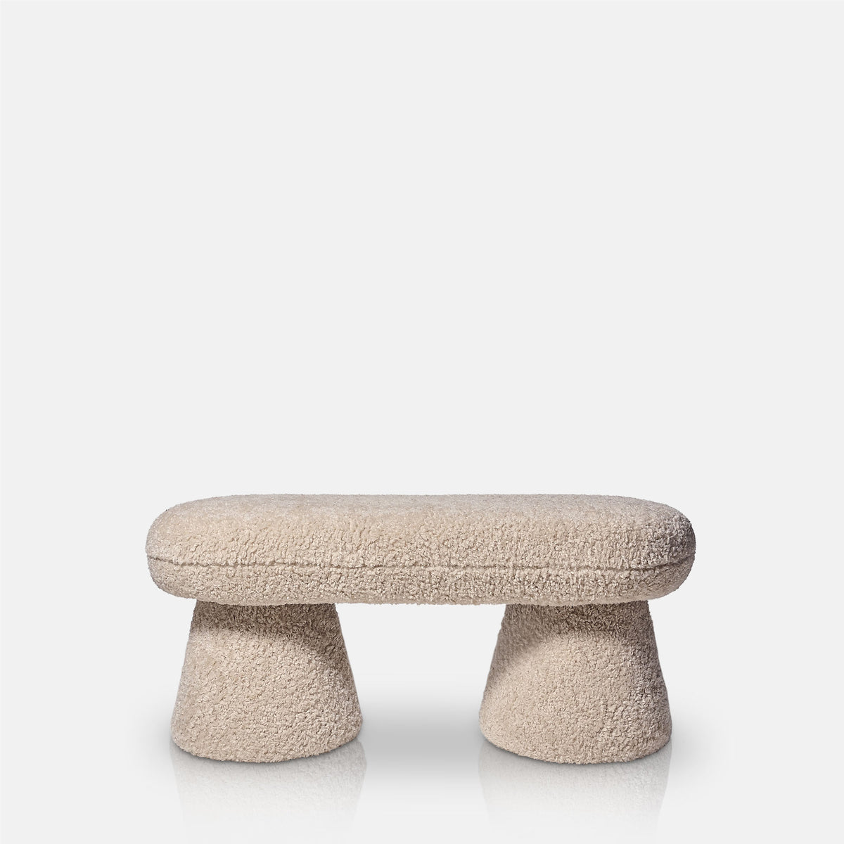 Cut out image Beige boucle bench with a curved upholstered design and soft textured teddy fabric finish. Tulip boucle bench by Abigail Ahern, a luxury modern seating piece perfect for bedrooms, hallways, living rooms and contemporary interiors. Elegant accent furniture designed to add warmth, comfort and sophisticated style to modern home decor.