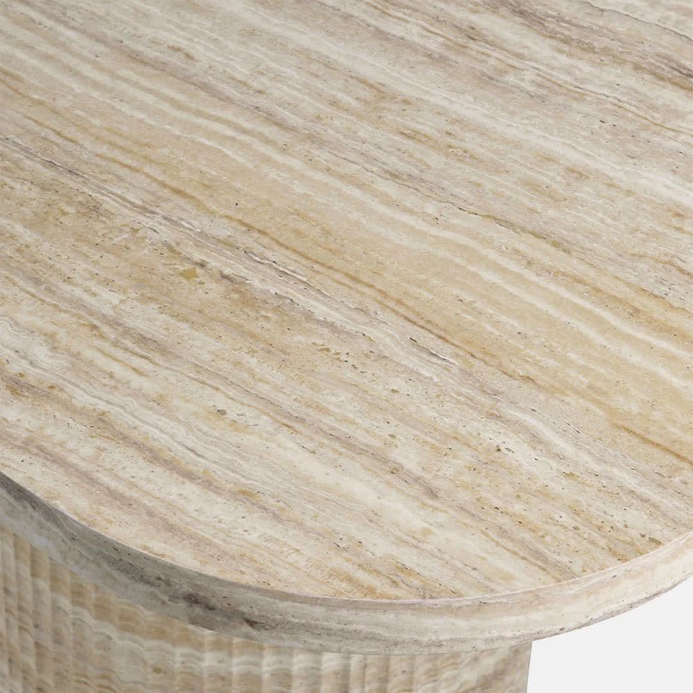 Westwood faux travertine dining table shown close up, revealing the pale cream and beige patterned top, rounded corner and softly curved edge above its support.