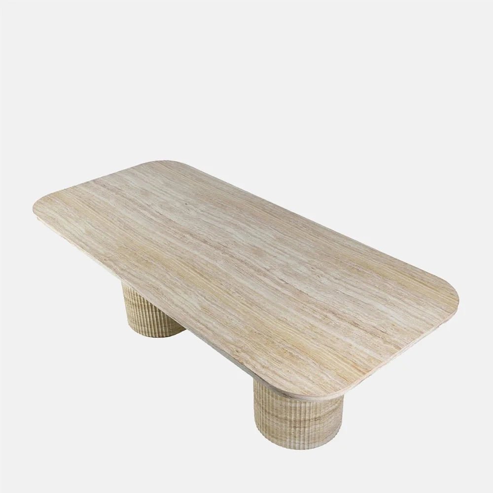 Westwood faux travertine dining table viewed from above at an angle, showing its pale rectangular top, rounded corners, layered stone pattern and two cylindrical supports.