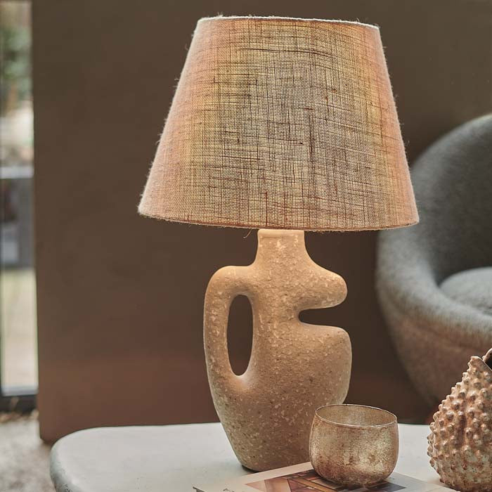 Table lamp with jute shade and grey sculptural base.