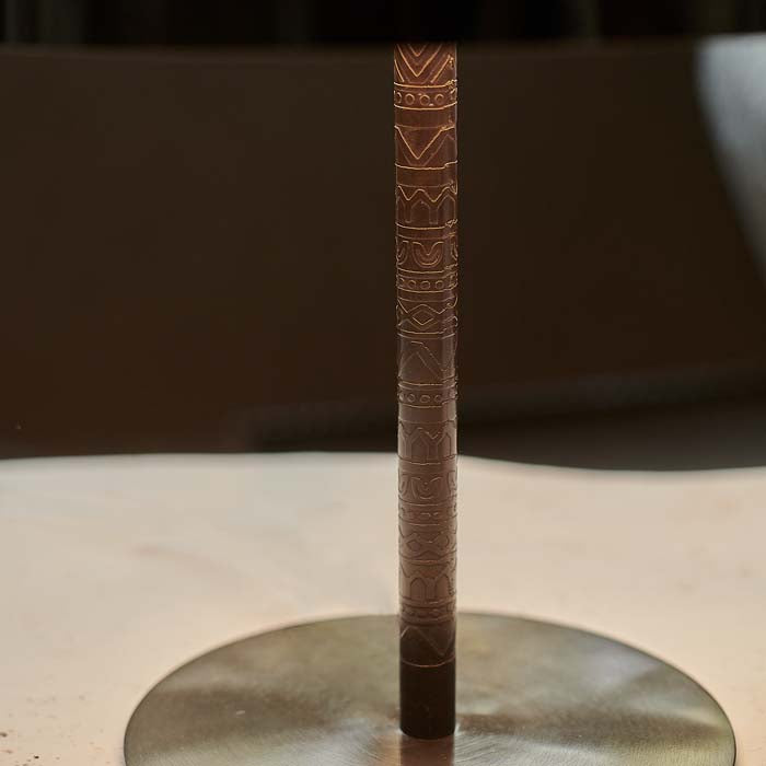 Engraved pattern markings on slim iron lamp base.