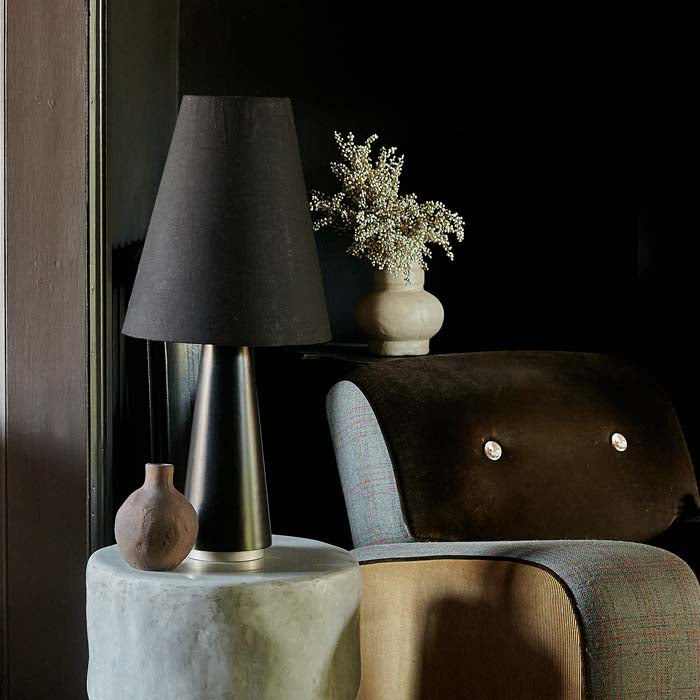 Large black table lamp with metal base and fabric shade.