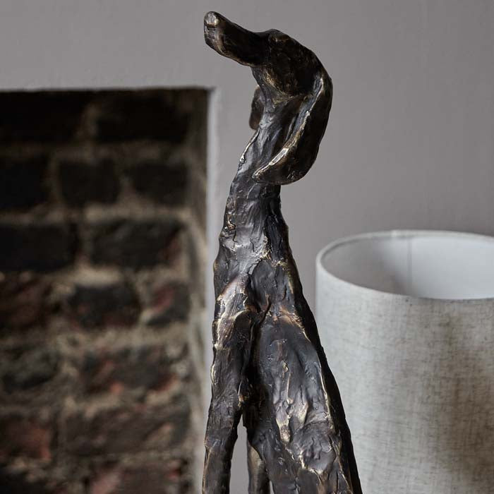 Rustic textured finish on a dog sculpture finished in bronze-look glaze.