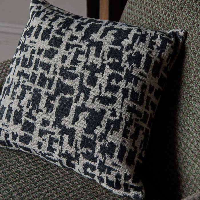 Square shaped woven cushion in natural and black tones.