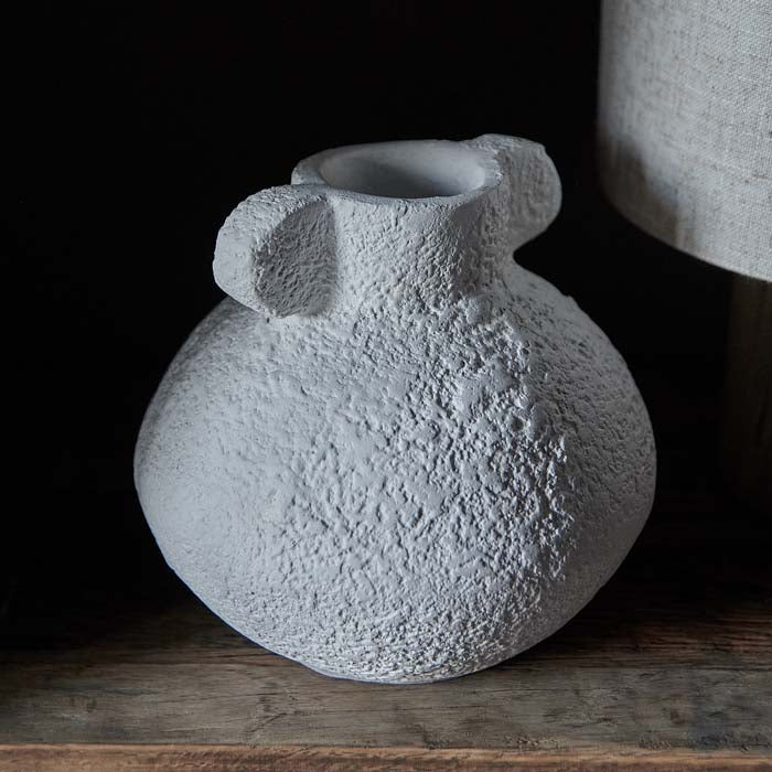 Rustic texture on white curved round vase.