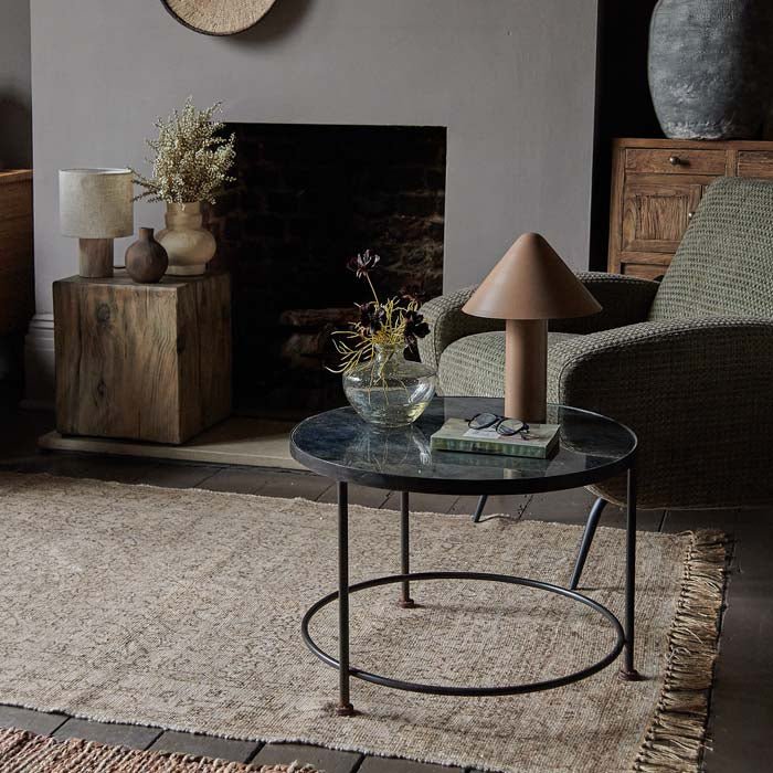 Round printed glass coffee table sat on a cream rug