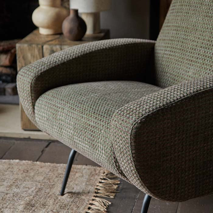 Green and brown woven fabric on upholstered lounge chair.