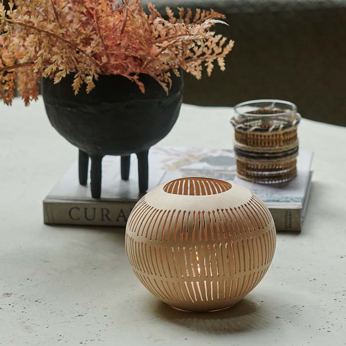 Round coconut tealight holder with cut-out stripe design.