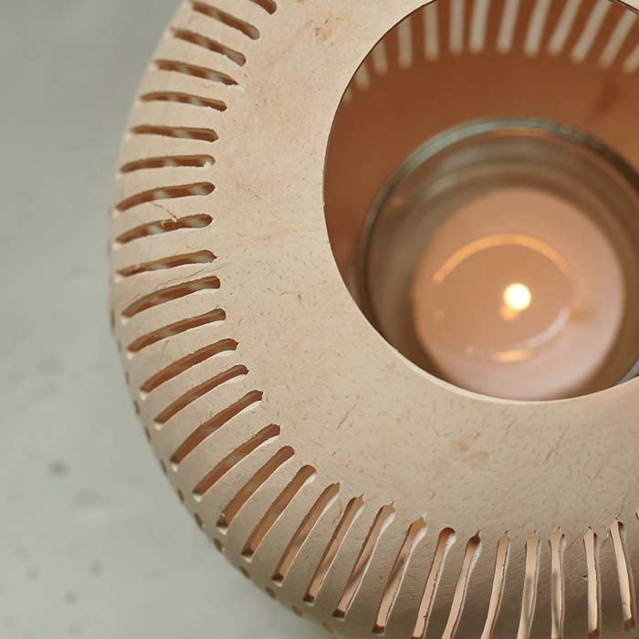 Tealight candle burning inside a natural coconut candle holder.
