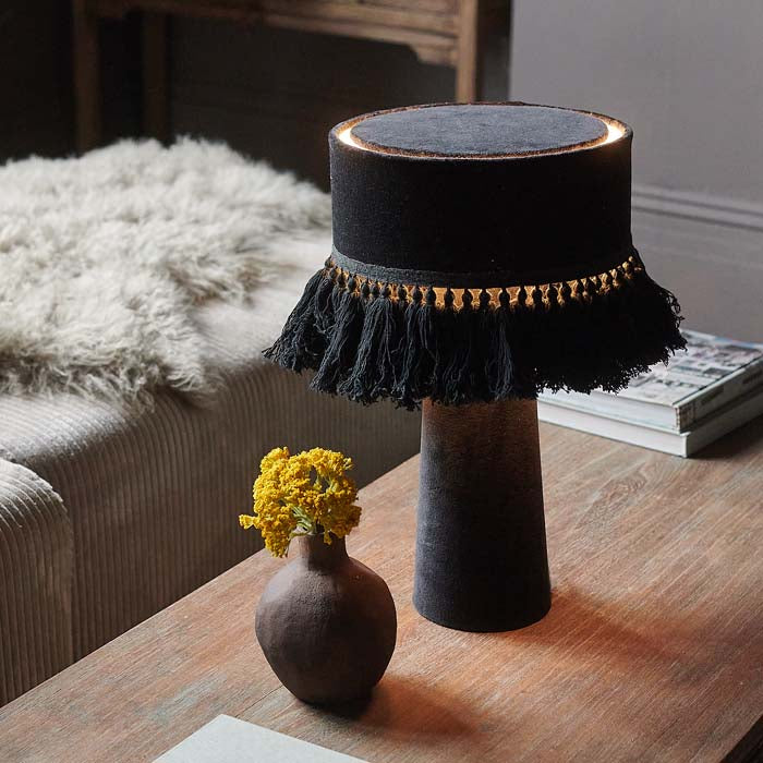 Black velvet table lamp with tasseled fringe on shade.