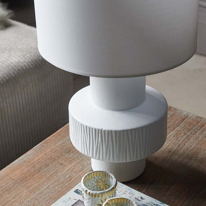 Textured decorative design on white ceramic table lamp base.