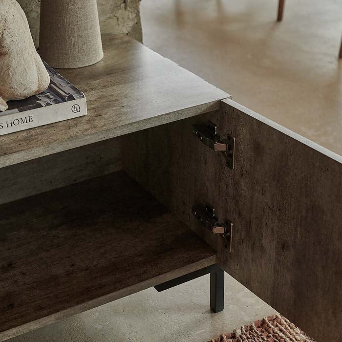 Faux-concrete tv unit with cabinet door open to reveal storage space inside.