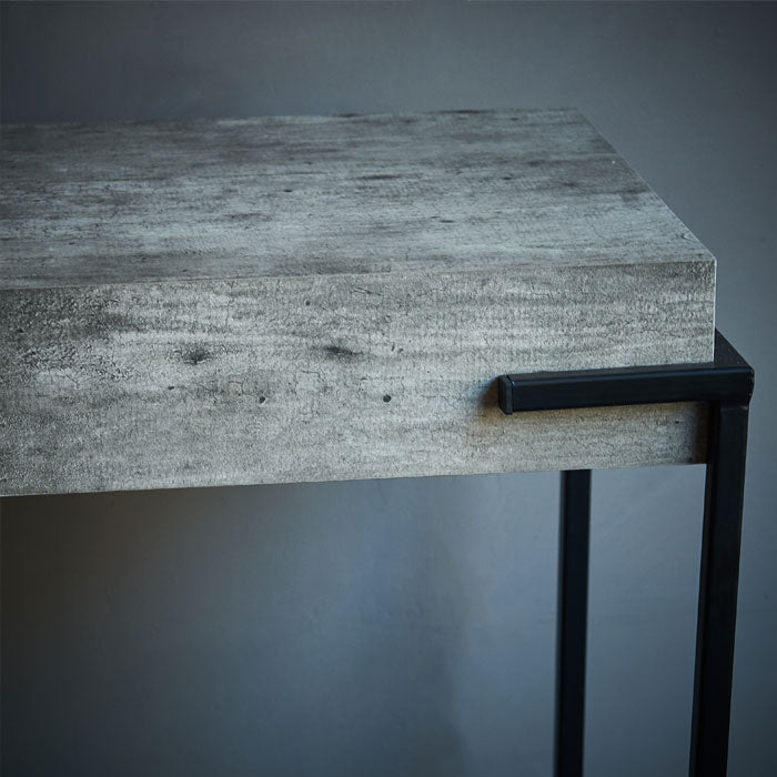 Faux concrete console table with black iron legs.