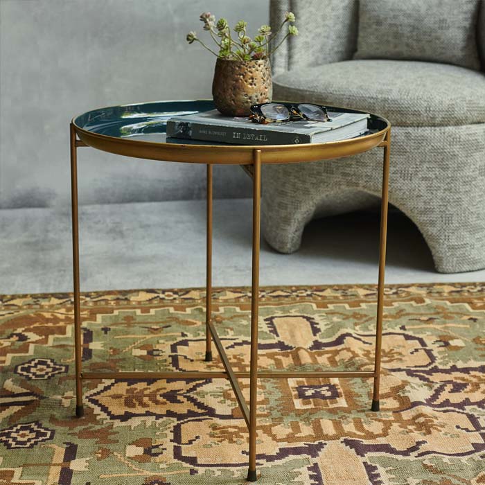 Blue enamel tray table top with a gold frame sat on a rug