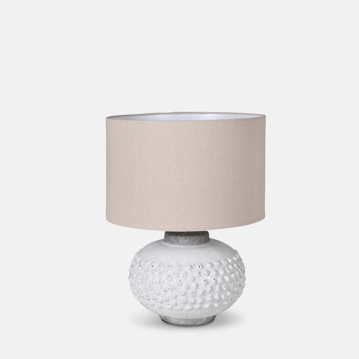 Round white textured bobble table lamp base with cream shade.