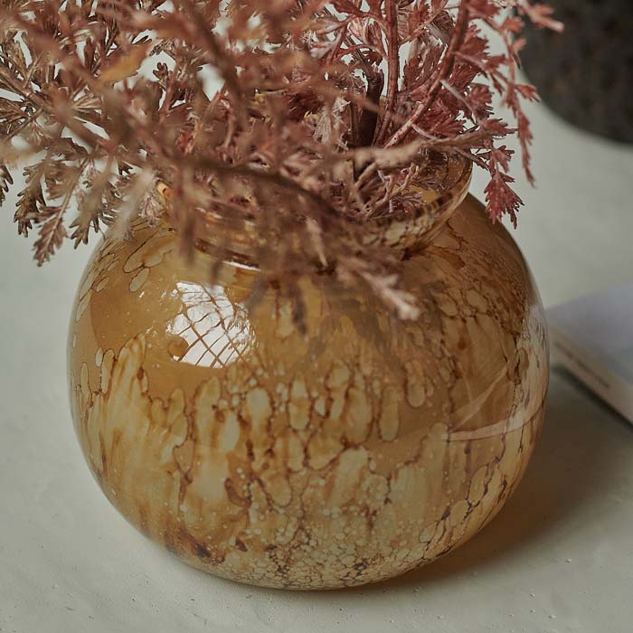 Brown marbled glass vase in low round shape.