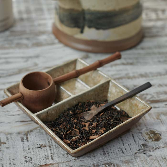 Loose tea leaves inside a ceramic serving tray.