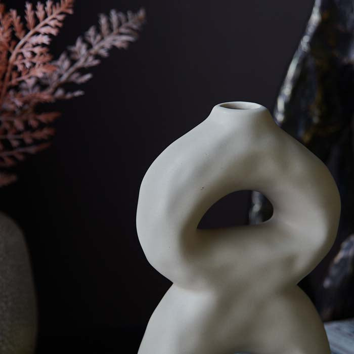 Matt cream surface of an abstract sculpted vase