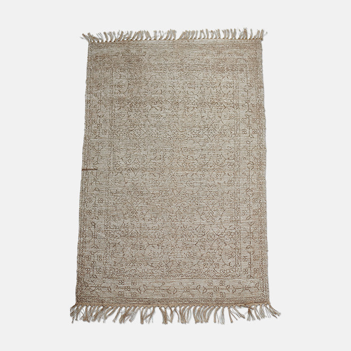 Large jute and polyester woven rug with delicate floral pattern design and tasselled edges.