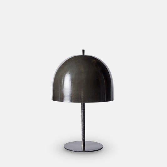 Black iron table lamp with slim base and large curved dome shade.