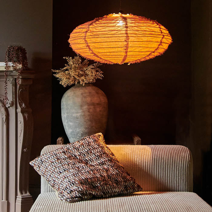 Switched on oval fabric pendant light in brown hanging over a grey corduroy sofa