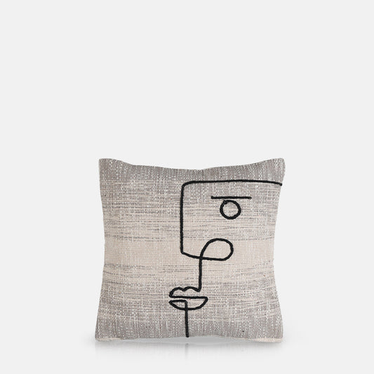 Square cushion with woven grey cotton cover with black embroidered abstract face design.