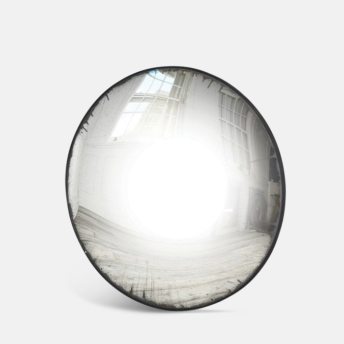 A cutout of the Farah Convex Mirror, an oversized round mirror with a slim black frame.
