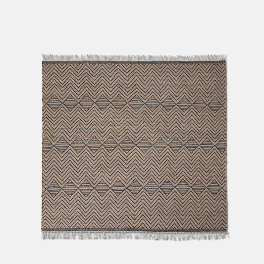 Large flat weave brown rug with black zig-zag pattern and fringe.